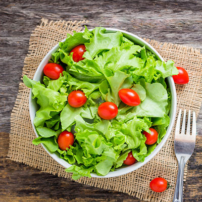 Delicious and healthy salad with tomatoes on an office desk